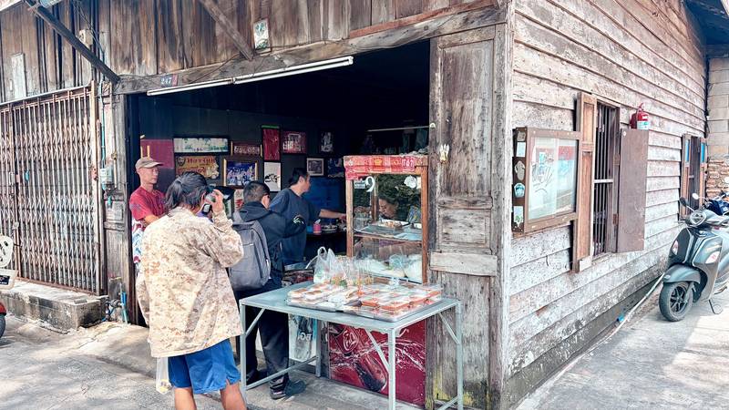 หน้าร้านเปิดโล่งกับตู้ก๋วยจั๊บและลูกค้าที่รอสั่ง